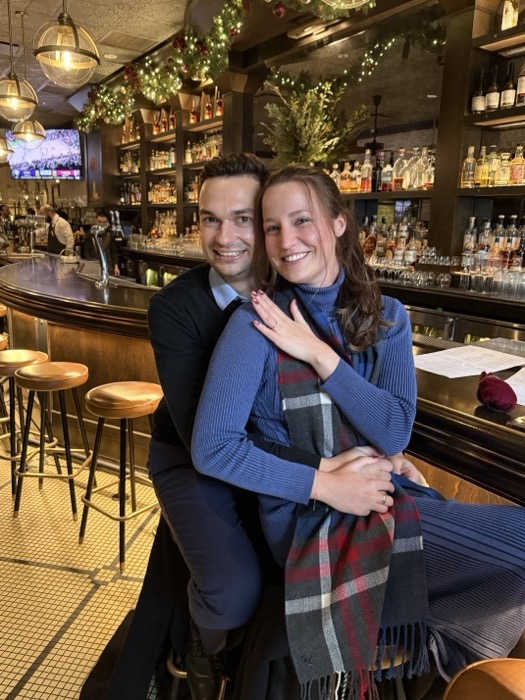 Michal and Austin hugging at a bar